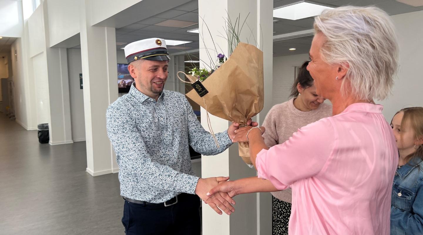 Årets første student på Rybners EUX Business Vitaliy får overrakt en buket blomster af uddannelseschef Marianne Kirk Foto: Rybners